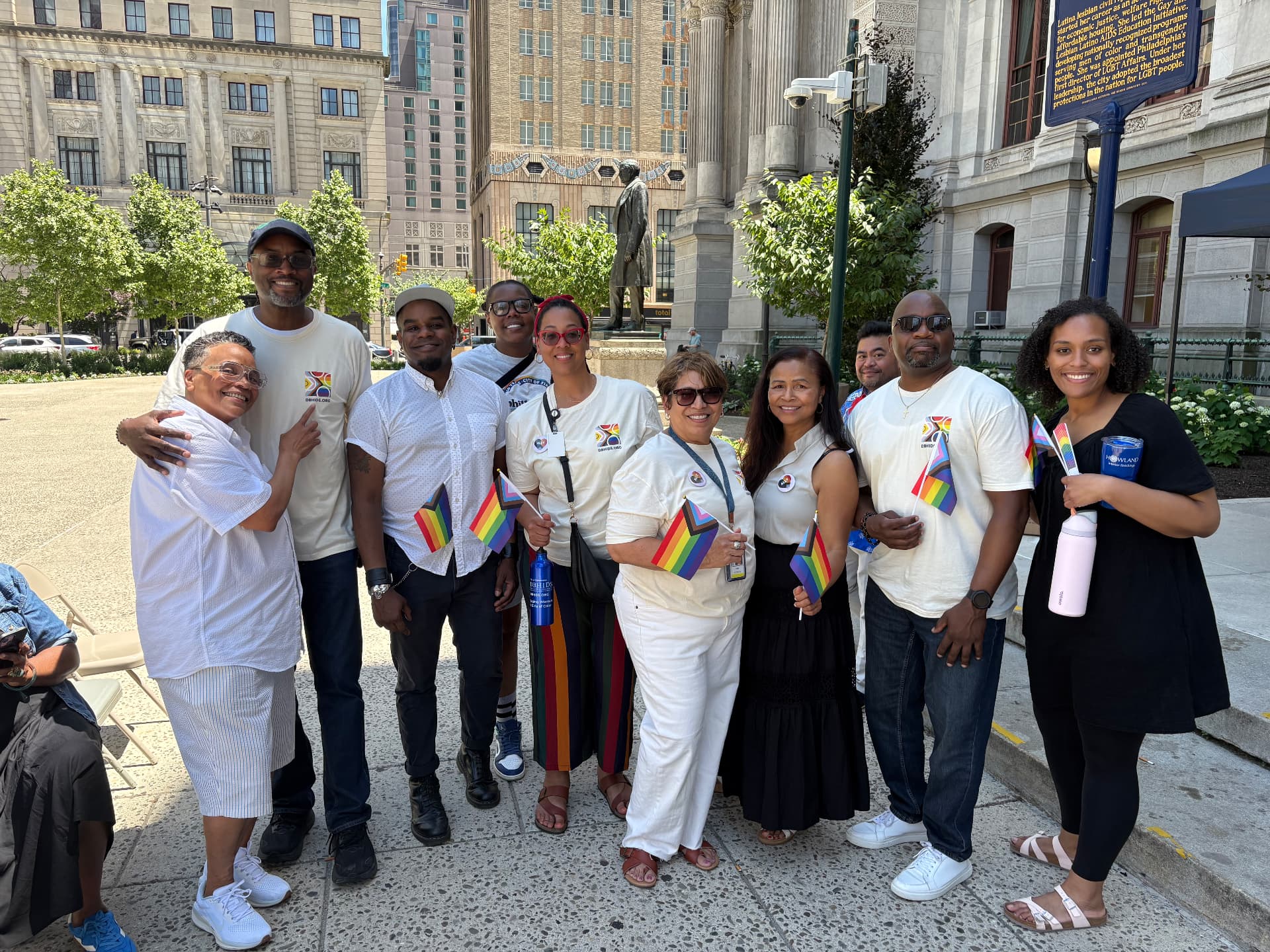 Womxn Beyond Borders wellness team and community members gathered together holding pride flags